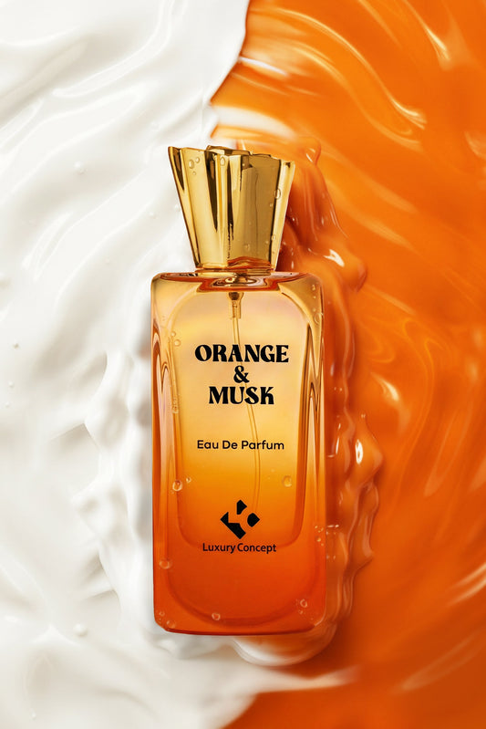 An orange and amber Eau De Parfum bottle with a gold cap, labeled 'ORANGE & MUSK' and 'Luxury Concept', set against a split background of white cream and orange liquid swirls.