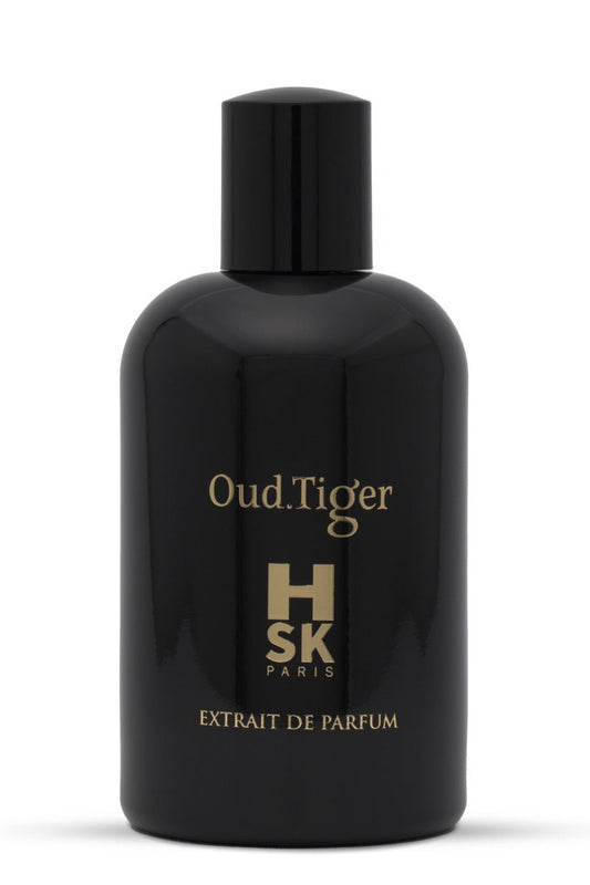 A glossy black bottle of HSK Oud.Tiger Extrait de Parfum with gold lettering, set against a plain white background.